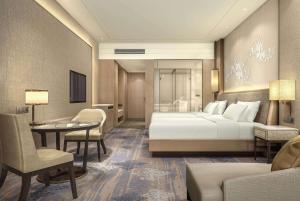 um quarto de hotel com uma cama, uma mesa e cadeiras em Wyndham Baise Resort em Baise