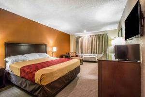 um quarto de hotel com uma cama e uma televisão de ecrã plano em Baymont by Wyndham Ontario em Ontario