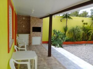 um quarto com uma mesa e cadeiras e uma parede amarela em Pousada Cabral em São Gabriel