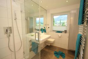 uma casa de banho com um chuveiro, um lavatório e um WC. em Ferienwohnungen Alpentraum - Alpennest 1 und Alpennest 2 em Oberstdorf