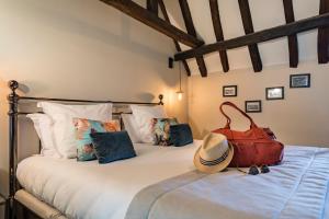 a bed with a purse and a hat on it at Le Général d'Elbée Hotel & Spa - Teritoria in Noirmoutier-en-l'lle