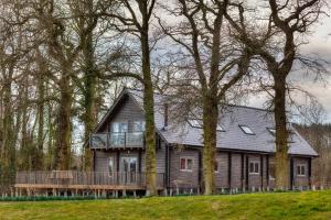a large wooden house with a deck in the woods at iLodge Ultra in Louth