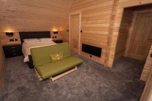 a bedroom with a bed and a green chair at iLodge Ultra in Louth