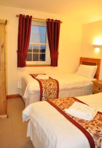 a hotel room with three beds and a window at THE OLD FARMHOUSE in Holmrook