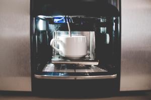 una tazza di caffè viene preparata in un forno a microonde di Hotel Bacco Rooms and Breakfast a Pietra Ligure
