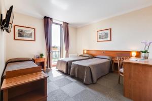 Un pat sau paturi într-o cameră la Romoli Hotel