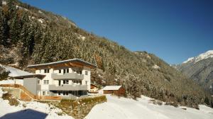 un edificio al lado de una montaña nevada en Bergblick, en Finkenberg