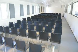 an empty room with chairs in a classroom at Pension Geerlisburg in Kloten