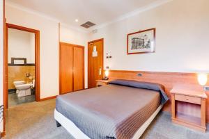 a bedroom with a bed and a bathroom with a toilet at Romoli Hotel in Rome