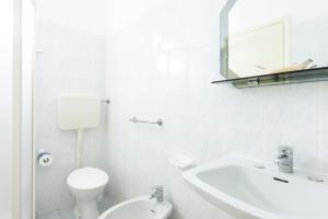 biała łazienka z toaletą i umywalką w obiekcie Hotel Verde Luna w mieście Cervia