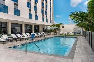 a swimming pool with lounge chairs and a hotel at Comfort Inn & Suites Miami International Airport in Miami