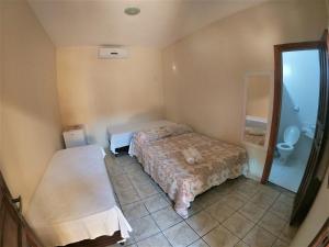 um pequeno quarto com uma cama e um WC em Pousada Aruanã em Arraial d'Ajuda