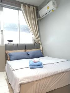 曼谷的住宿－My Home N1 - BTS Ratchathewi，一间卧室配有一张带蓝色毛巾的床