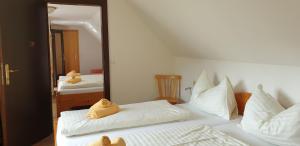 a bedroom with a white bed with towels on it at Hotel Pension Pürcherhof in Gröbming