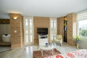 a living room with a tv and a couch at Bella Tierra Hotel Boutique in Tibasosa