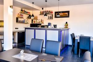 a restaurant with a bar with blue chairs and tables at Casa Mara in Ocna Şugatag