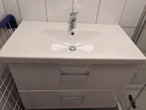 een witte wastafel in een witte badkamer met bij 109 Apartment Bergner 4-8 Pers 68m2 in Klagenfurt