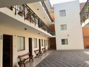 an empty hallway with benches in a building at Hostal La Casona in Pisco