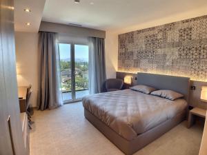 a bedroom with a large bed and a large window at Attica Résidences, Lausanne in Saint-Sulpice