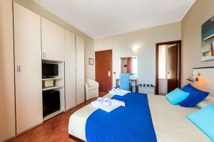 a bedroom with a blue and white bed and a television at Hotel Mediterraneo in Sapri