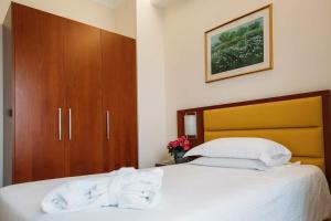 una camera da letto con un letto e asciugamani bianchi di Hotel Terme Antoniano a Montegrotto Terme