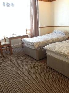 a hotel room with two beds and a table at Sunnyside Accommodation in Skegness