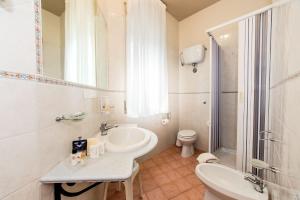 bagno bianco con lavandino e servizi igienici di Hotel Mediterraneo a Sapri