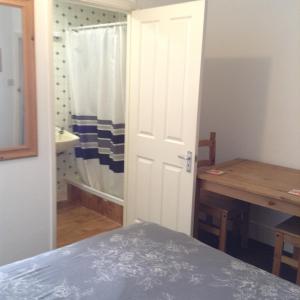 1 dormitorio con cama, mesa y puerta en Sunnyside Accommodation, en Skegness