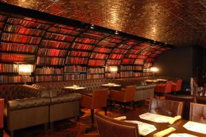 a restaurant with tables and chairs and a library of books at Clanree Hotel & Leisure Centre in Letterkenny