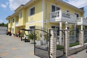 a yellow house with a gate in front of it at Villa Katharina in Rust