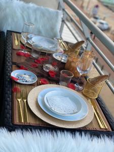 a table with plates and wine glasses on a table at Superbe Appart vue mer avec balcon in Blankenberge