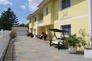 a yellow building with an umbrella and a patio at Villa Katharina in Rust