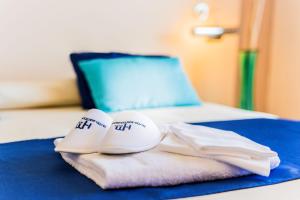 - une paire de chaussures et de serviettes sur un lit dans l'établissement Hotel Mediterraneo, à Sapri