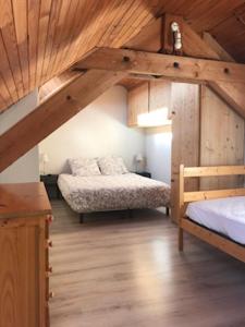een slaapkamer met 2 bedden en een houten plafond bij Appartement centre village in Villard-de-Lans