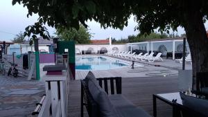 - une piscine entourée de chaises longues blanches dans l'établissement Guest House KOLESHEVI, à Byal Izvor