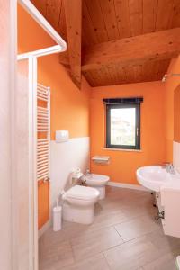 an orange bathroom with a toilet and a sink at La Rotonda Trilocale vista mare in Albinia