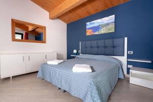 a blue bedroom with a bed and a blue wall at La Rotonda Trilocale vista mare in Albinia