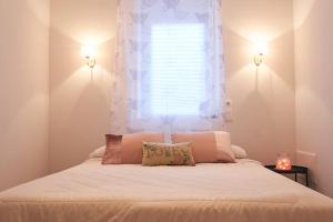 維雅潘多的住宿－La casa de tus sueños，一间卧室配有一张带窗户和枕头的床