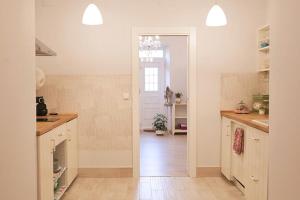 cocina con paredes blancas, suelo de madera y pasillo en La casa de tus sueños, en Villalpando