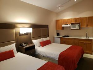 a hotel room with two beds and a kitchen at Sun Peaks Lodge in Sun Peaks