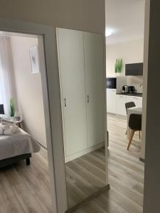 a bedroom with a mirror and a bed and a kitchen at Apartament Walczaka 11 MIEJSCE PARKINGOWE in Gorzów Wielkopolski