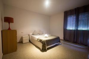 een slaapkamer met een bed en een raam bij Front Sun Beach Apartment in Valencia