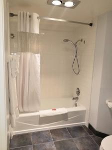 a bathroom with a shower and a white tub at Tamarack Beach Hotel in Carlsbad