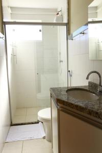 W łazience znajduje się prysznic, umywalka i toaleta. w obiekcie Rivello Apart Hotel w mieście Sete Lagoas