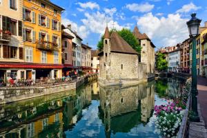 a river in a city with buildings next to a canal at La petite Venise in Annecy
