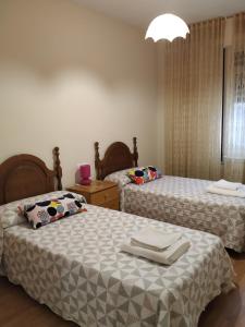 two beds in a hotel room with towels on them at Camino Real in Molinaseca