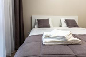 Una pila de toallas encima de una cama en AM Apartamentai, en Klaipėda