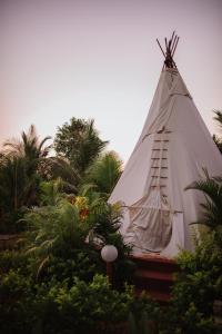 a large white teepee with trees and plants at Wigwam in Mandrem
