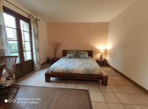 a bedroom with a bed and a large window at Les Prunelliers in Rambouillet