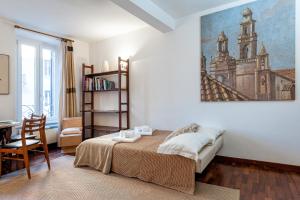羅馬的住宿－IREX Popolo Square private apartment，卧室配有一张床和一张书桌,墙上挂有绘画作品